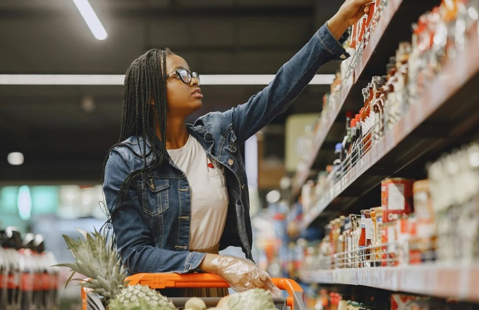 Shopper choosing items from a supermarket shelf